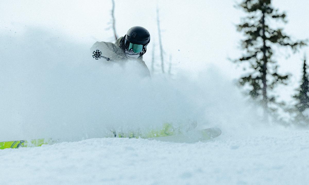 Person skiing in deep snow with trees in the background